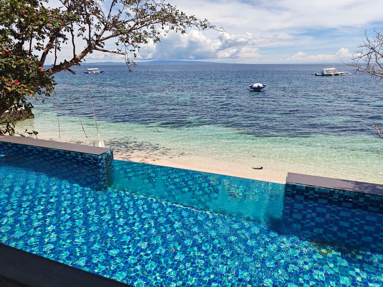 The infinity pool meeting the Tañon strait at G Boutique Resort, Santander