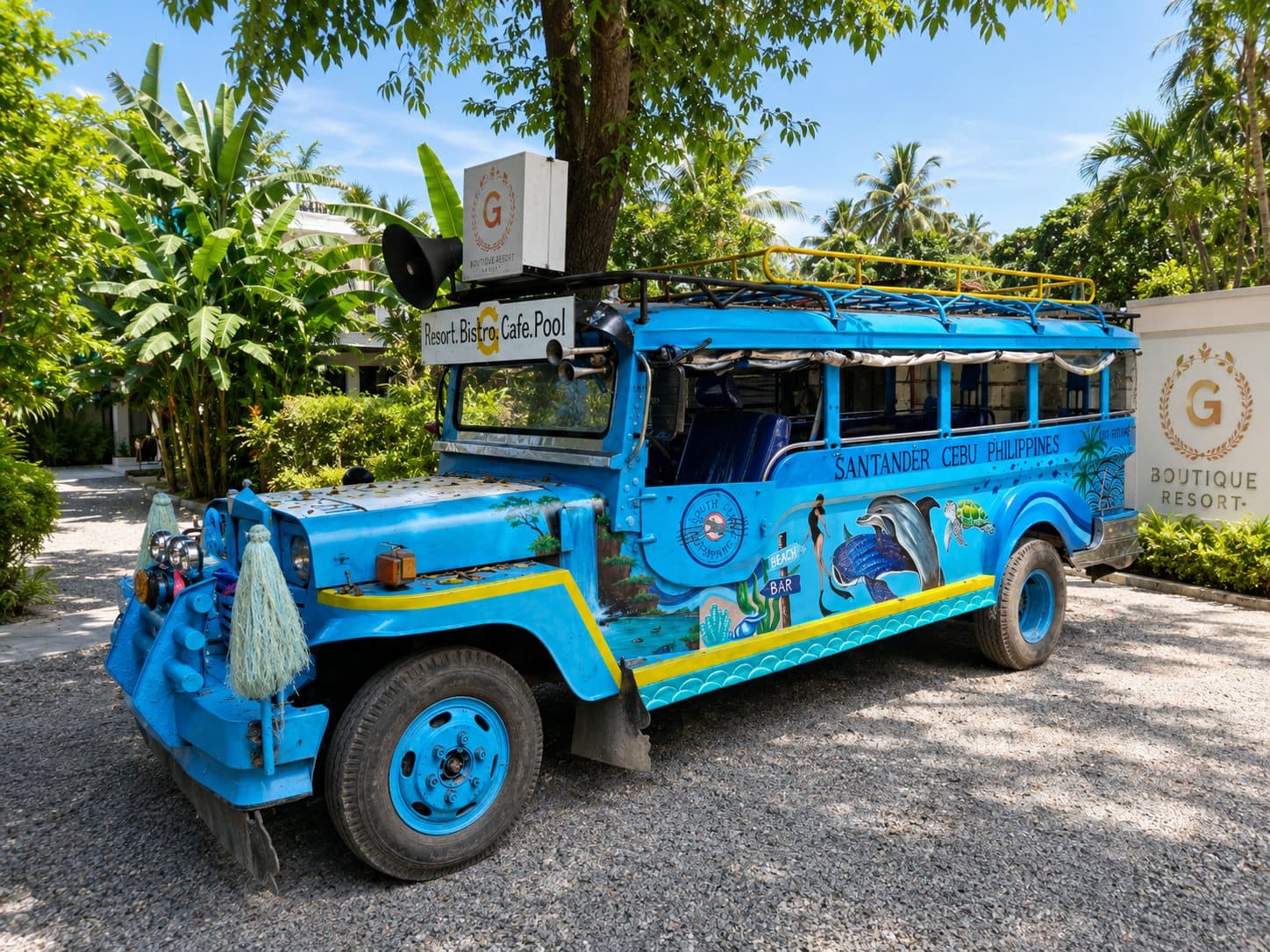 The blue G Boutique shuttle beside the resort sign